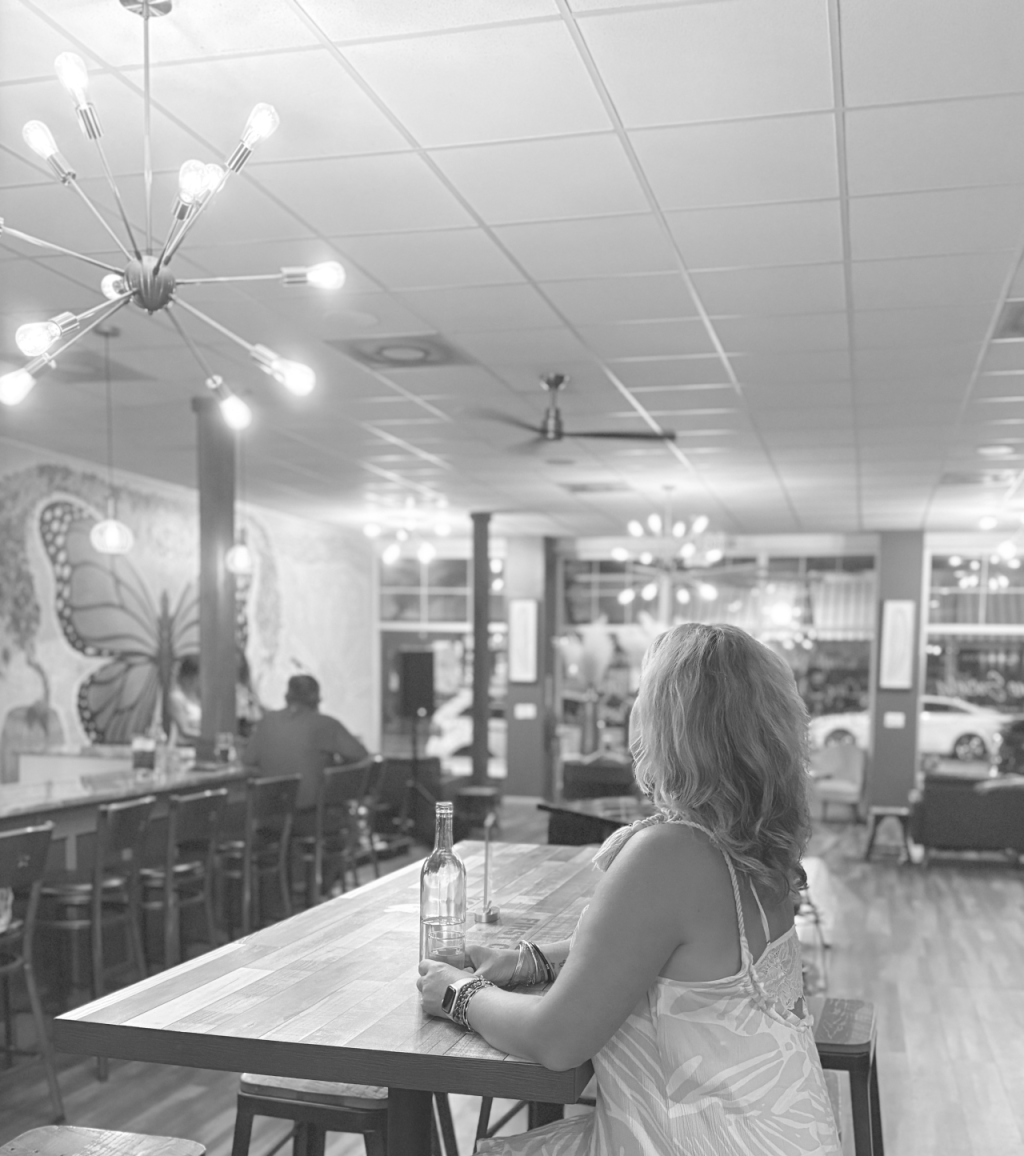 picture of the author sitting in a bar by herself