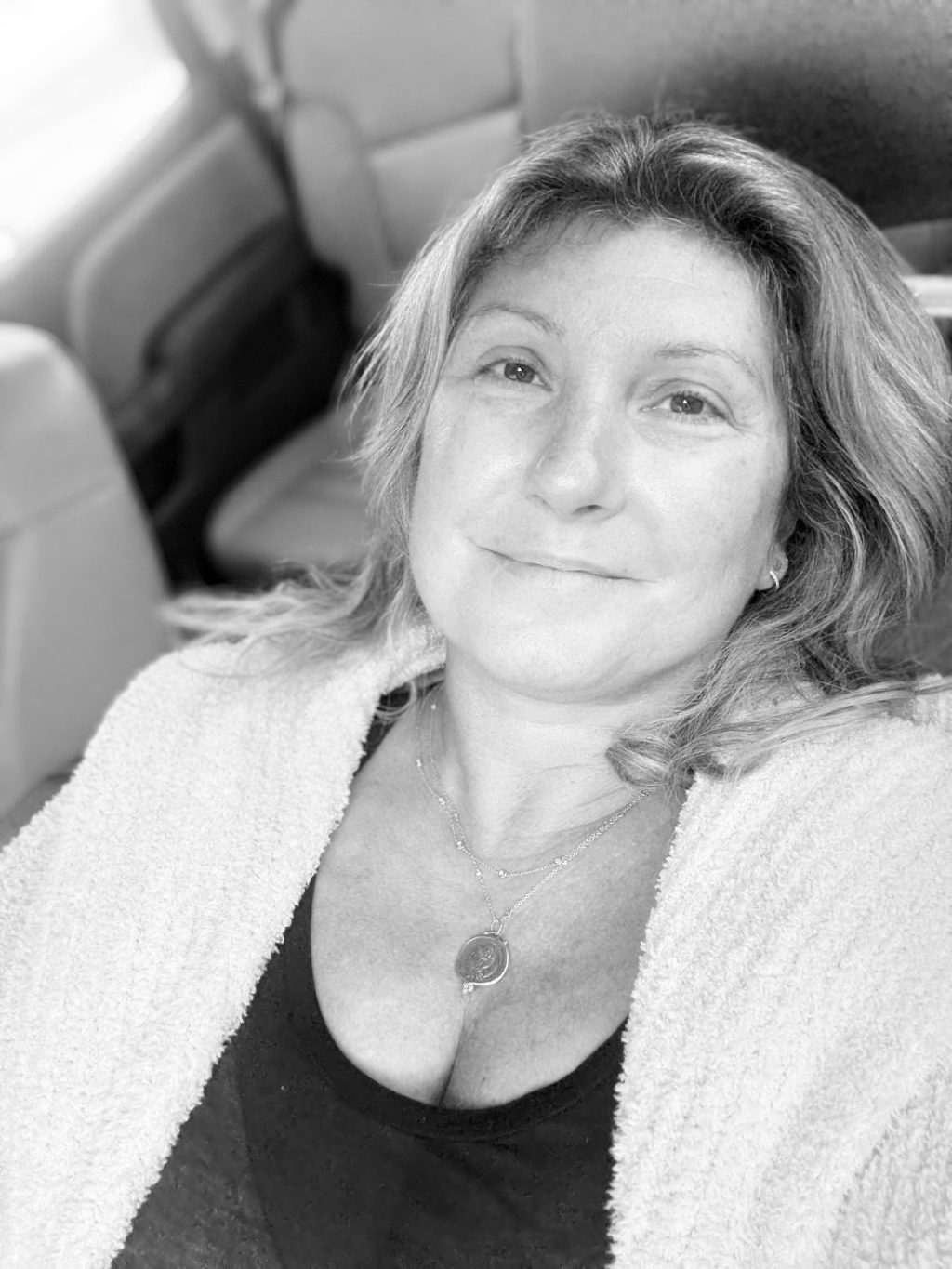 picture of author sitting in her car in carline